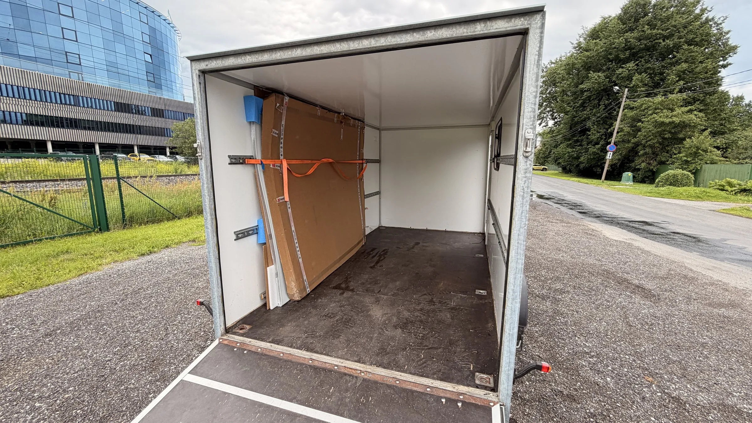 Open trailer showing the full-width ramp and tie-down rails